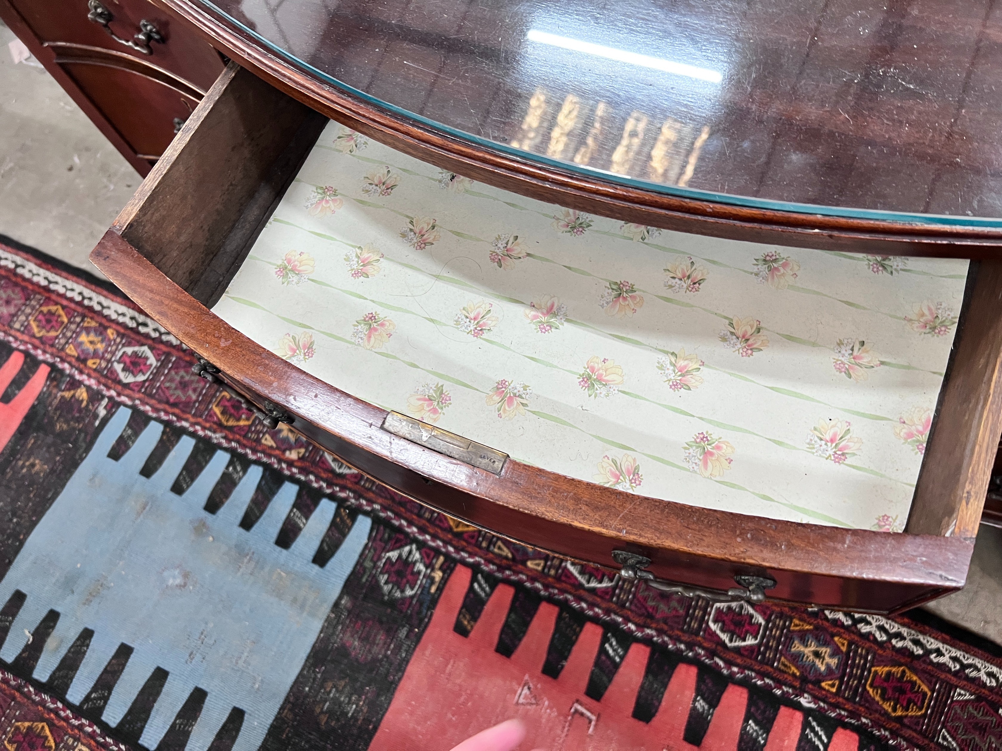 A 1920's serpentine mahogany kneehole dressing table, width 120cm, depth 61cm, height 76cm *Please note the sale commences at 9am.